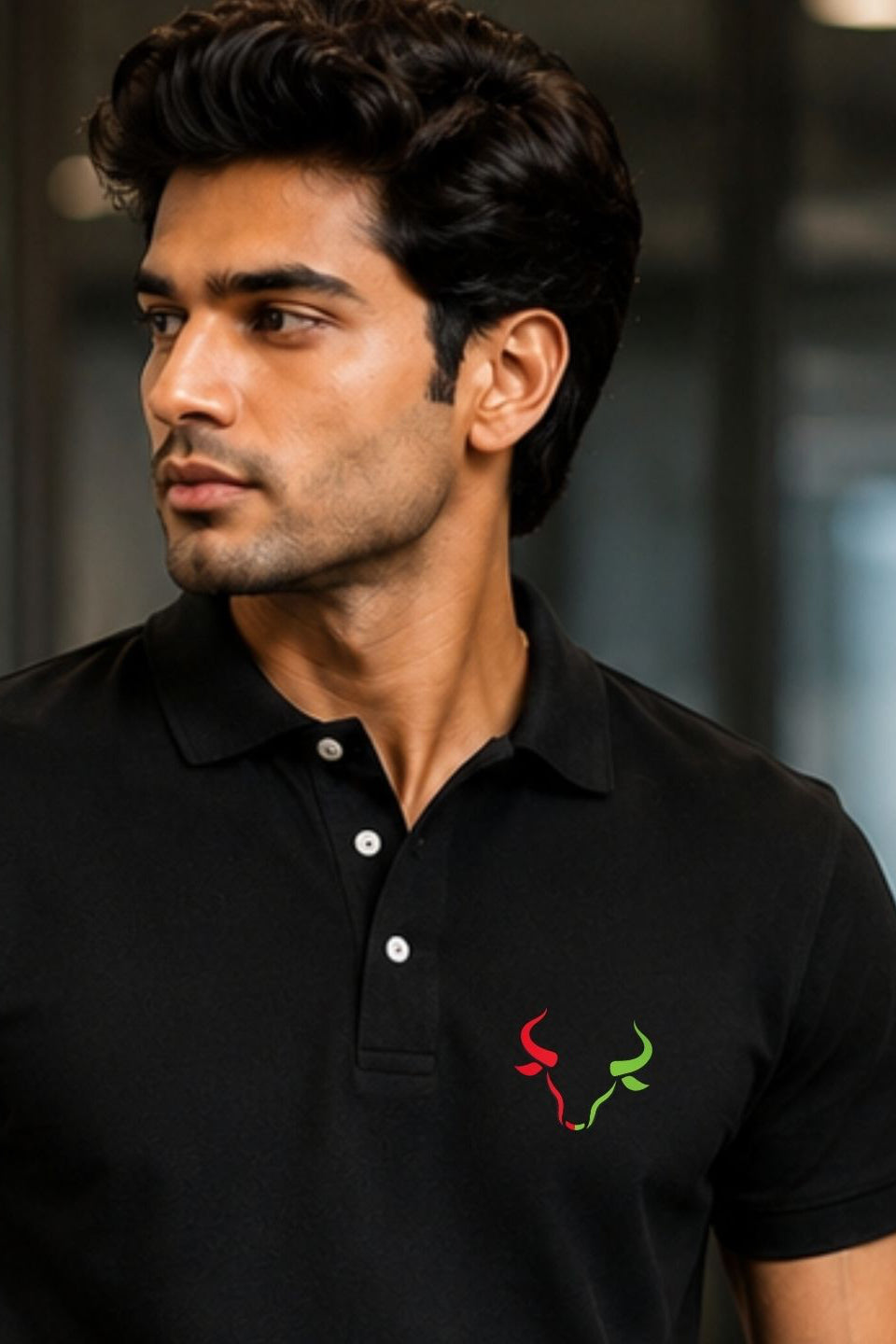 Man wearing a black polo shirt with a logo on a blurred background