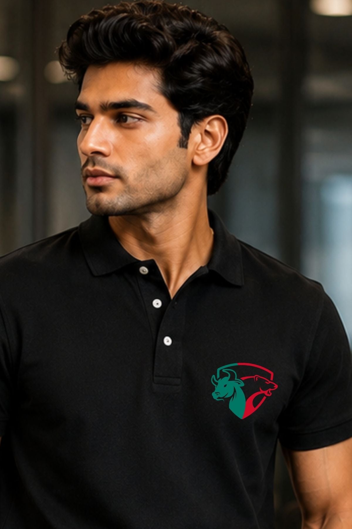Man wearing a black polo shirt with a logo on a blurred background